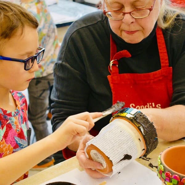Decorating a pot - artist with a young student